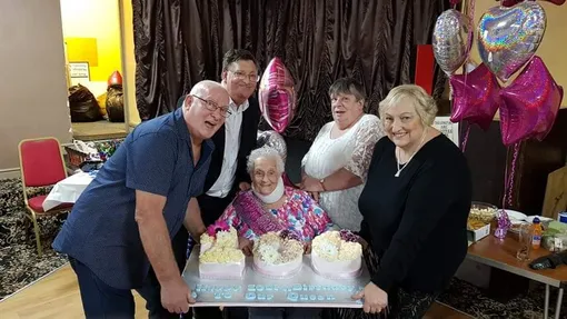 пожилая женщина отмечает день рождения в компании друзей
