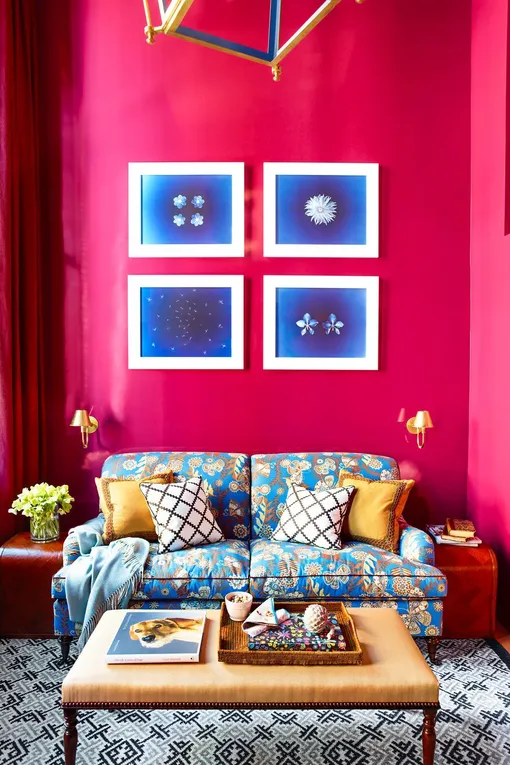 Ярко-розовая гостиная с голубым диваном и предметами искусства