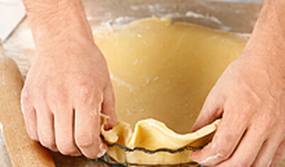Тесто раскатайте в пласт по размеру формы, стараясь использовать меньше муки, прижмите тесто к стенкам и дну смазанной формы с антипригарным покрытием. 
