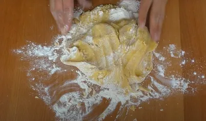 Когда тесто для медовика станет тёплым, начните вымешивать его руками. У вас получится мягкое, но не плотное тесто. 
