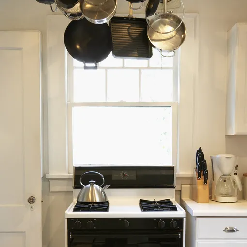 Подвешенные к потолку кастрюли и сковороды освобождают пространство на столешнице и в шкафах