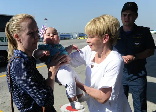 Елизавета Глинка помогает женщине с ребенком во время посадки на спецборт МЧС РФ в аэропорту Ростова-на-Дону перед отправкой детей из Донбасса для лечения в медицинских учреждениях Москвы.