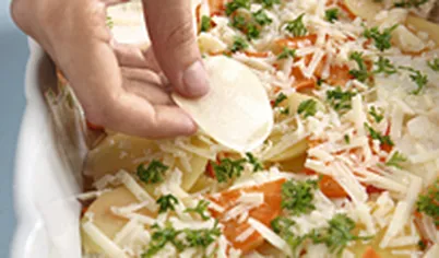 Выложите овощную массу слоем в форму для запекания, кружочки картофеля распределите сверху.
