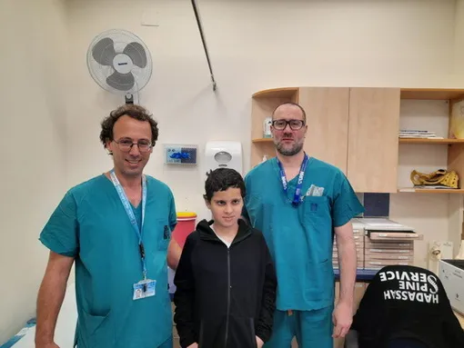Д-р Охад Эйнав и Зив Аса с 12-летним Сулейманом Хасаном в клинике после выздоровления мальчика в результате операции по прикреплению головы к шее