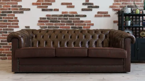 Коричневый кожаный диван в комнате в стиле лофт