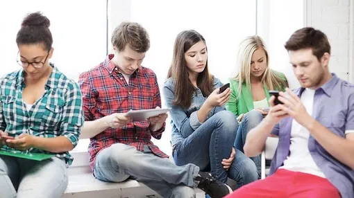 молодые люди, молодые люди со смартфонами, парни и девушки смотря в смартфоны