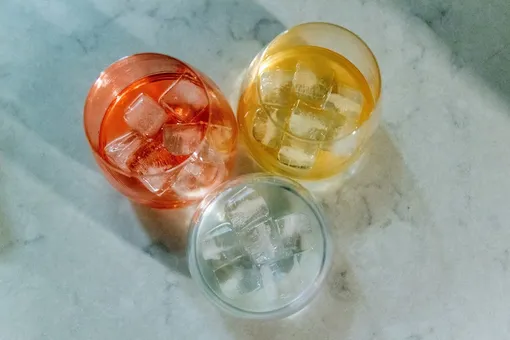 Разноцветные напитки со льдом в стеклянных стаканах
