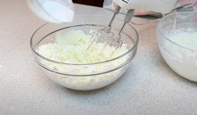 Пришло время готовить сливочный крем. Взбейте миксером на максимальной скорости размягченное сливочное масло и сахарную пудру (минут 5), затем добавьте холодный сливочный сыр и взбивайте еще минут 5-7.
