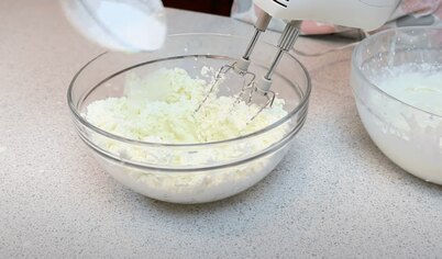 Пришло время готовить сливочный крем. Взбейте миксером на максимальной скорости размягченное сливочное масло и сахарную пудру (минут 5), затем добавьте холодный сливочный сыр и взбивайте еще минут 5-7. 