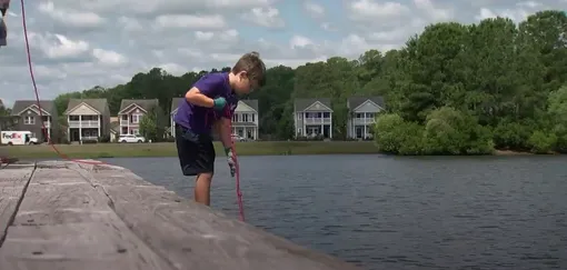 Шестилетний Нокс исследует дно озера с помощью магнита