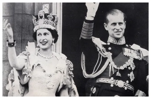 Королева Елизавета II и принц Филипп машут рукой с балкона Букингемского дворца после коронации.