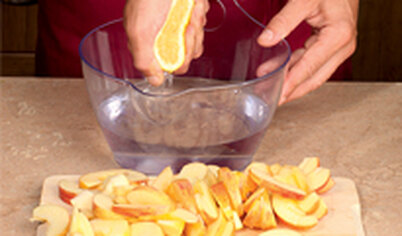 Яблоки нарежьте тонкими ломтиками. Выложите в чашу. Лимонный сок разведите водой и залейте яблоки.