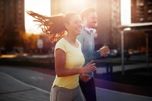 Улыбающаяся пара совершает пробежку по улице цитаты про спорт и здоровье