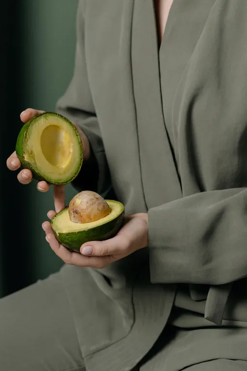 Девушка держит в руках авокадо