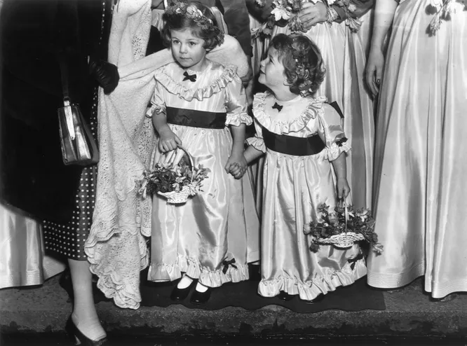 4-летняя Камилла (слева) со своей младшей сестрой Аннабель в качестве цветочниц на свадьбе в 1952 году