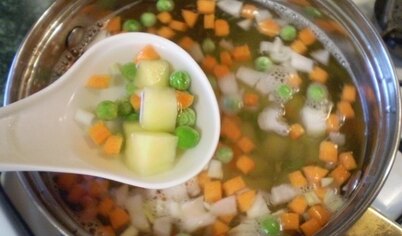 В кипящую соленую воду выложите все овощи, кроме зелени. Варите 20 минут.