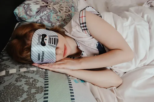 девушка в маске для сна спит