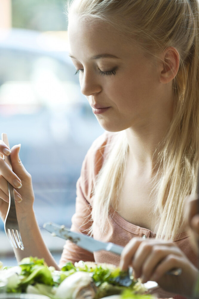 Девушка ест салат, как рассчитать дефицит калорий