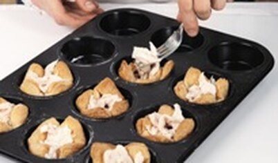 Достаньте из духовки испеченные тарталетки. Куриные грудки, предварительно отваренные и нарезанные, распределите по	тарталеткам.