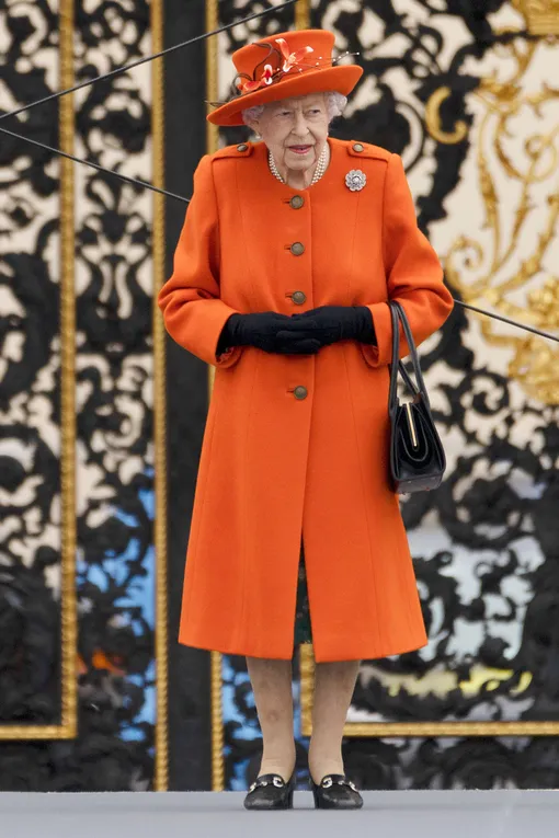 Жизнерадостный оранжевый цвет пальто компенсируется строгостью фасона