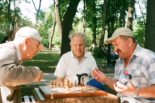 трое мужчин играют в шахматы