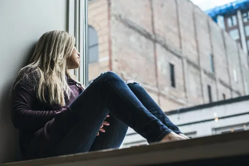 Девушка сидит около окна, депрессия, когнитивно-поведенческая терапия