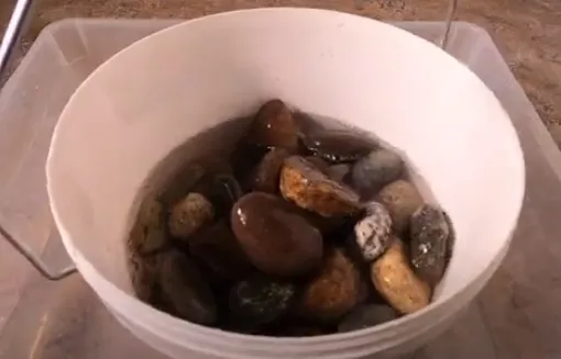 Мытье камней в ведре с водой