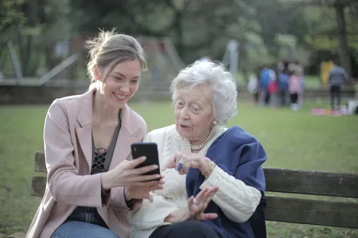Пожилая женщина, молодая женщина, смартфон, парк, скамейка