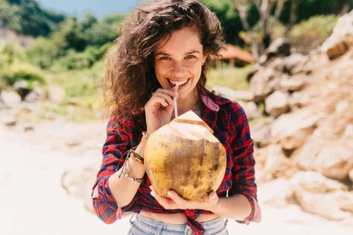 Девушка пьет кокосовую воду