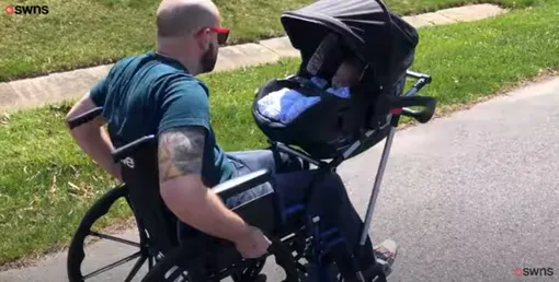 отец на инвалидной коляске гуляет с ребенком