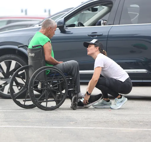 Дженнифер Гарнер надевает свои носки и обувь на бездомного