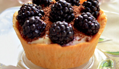 Наполните пирожные кремом, посыпьте тертым шоколадом, украсьте ежевикой или другими ягодами.