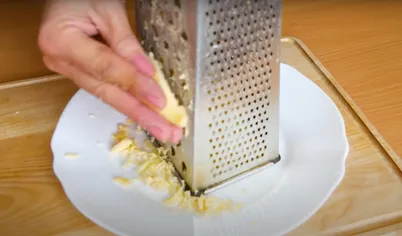 Крабовые палочки для рулета из лаваша нарезаем тонкими полосками. Сыр — натираем на мелкой тёрке. К сыру сразу добавляем очищенный и измельчённый чеснок и перемешиваем.
